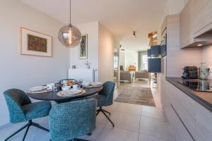 een keuken en eetkamer met een tafel en stoelen bij Smeysea - Stylish apartment in Sint-Idesbald in Sint-Idesbald