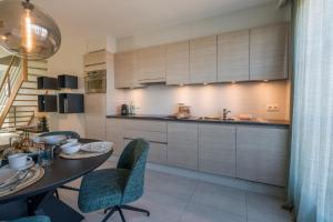 a kitchen with a table and chairs and a sink at Smeysea - Stylish apartment in Sint-Idesbald in Sint-Idesbald