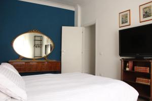 ローマにあるApartment Flaminioのベッドルーム(ベッド1台、鏡、テレビ付)