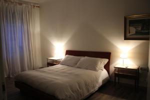 een slaapkamer met een bed met twee lampen op twee tafels bij Apartment Flaminio in Rome