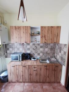 a kitchen with a sink and a microwave at APARTAMENT REGUN in Reghin