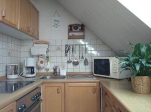 a kitchen with a sink and a microwave on a counter at Urlaub nähe Badesee und Strand - kostenlose Fahrräder in Berumbur