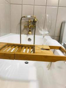 a wooden cutting board with a wine glass on a bath tub at The Throne in Johannesburg