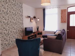 sala de estar con sofá y TV en L'artistique, 4 lits, 2 chambres, spacieux, atypique, en Amiens