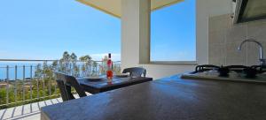 eine Küche mit einem Tisch und Meerblick in der Unterkunft NaturaMare Apartments - Piscina Idromassaggio con Vista Mare Aperta fino alle ore 22-00 in Capo Vaticano