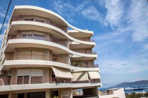 a tall building with balconies on the side of it at Lavrio Seaview 2bdr Apt 4 min dive from the sea in Lávrion