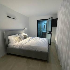1 dormitorio con 1 cama grande con sábanas blancas en DreAm_ram, en H̱azon