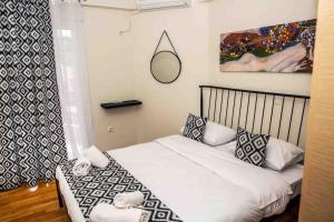 małą sypialnię z łóżkiem i lustrem w obiekcie Lavrio Seaview 2bdr Apt 4 min dive from the sea w mieście Lawrio