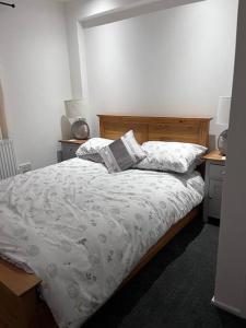 a bedroom with a bed and two pillows on it at Semi-detached chalet - Uddingston, Glasgow in Uddingston