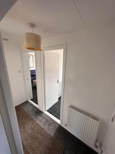 a room with a mirror and a hallway with a hallway at Semi-detached chalet - Uddingston, Glasgow in Uddingston