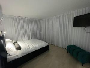 - une chambre avec un lit et un pouf vert dans l'établissement DreAm_ram, à H̱azon