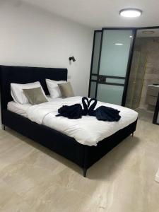 Un dormitorio con una cama con dos camisas negras. en DreAm_ram, en H̱azon