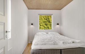 1 dormitorio con cama blanca y ventana en Nice Home In Dronningmlle With Kitchen, en Dronningmølle