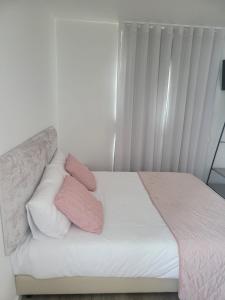 een bed met roze en witte kussens erop bij Alojamento Local Vitoria in Batalha