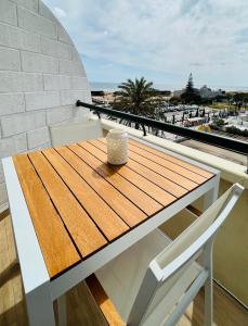a table and chairs on a balcony with a view of the ocean at Sunset Retreat 1a linha de mar in Monte Gordo