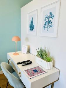 a white desk with a lamp and a plant on it at Sunset Retreat 1a linha de mar in Monte Gordo