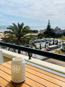 biała waza siedząca na drewnianym stole na balkonie w obiekcie Sunset Retreat 1a linha de mar w mieście Monte Gordo