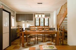 a kitchen and dining room with a wooden table and chairs at Reinis in Turaida