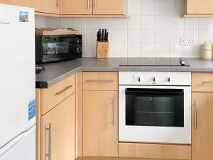 a kitchen with a stove and a microwave at Hydan Creek Gardens in Wootton Bridge