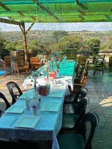 uma mesa longa com mesas e cadeiras azuis em Mahikeng Lodge em Magaliesburg