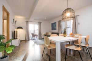 a dining room and living room with a white table and chairs at Flatsforyou Carmen in Valencia