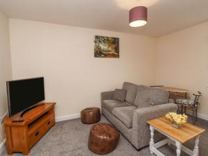 a living room with a couch and a tv at Stable End Cottage in Spilsby