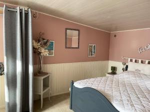 a bedroom with a bed with pink walls at Maison de 2 chambres avec jardin clos et wifi a Saint Pierre d'Oleron a 1 km de la plage in Saint-Pierre-dʼOléron