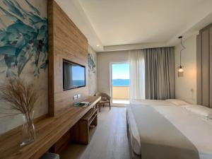 una camera d'albergo con un grande letto e una TV di Hotel Rex a Livorno