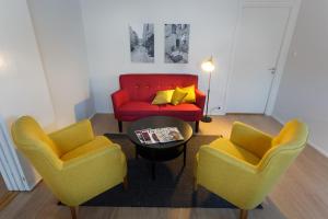 a living room with two chairs and a red couch at Forenom Serviced Apartments Helsinki Kruununhaka in Helsinki