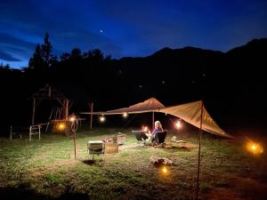 sabouしが في ماتسوموتو: امرأة جالسة في خيمة في الليل