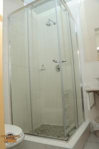 a shower stall in a bathroom with a toilet at The Hill Bed and Breakfast in Francistown