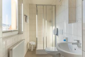 a white bathroom with a sink and a toilet at Hotel Kindler 2,0 Self-Check-In in Leoben