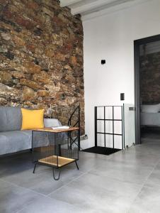 a living room with a couch and a stone wall at Stones By Syros Bnb in Ermoupoli