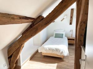 ein Schlafzimmer mit einem Bett im Dachgeschoss in der Unterkunft Le Relai de Boissée in Blois