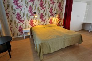 a bedroom with a bed with a yellow blanket at Forenom Serviced Apartments Helsinki Kruununhaka in Helsinki