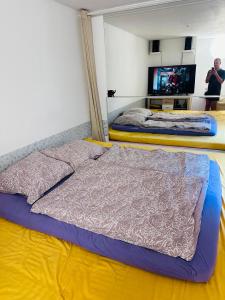 a bedroom with two beds and a tv in it at Tantra klub "Chaty Steva Jobse" in Prague