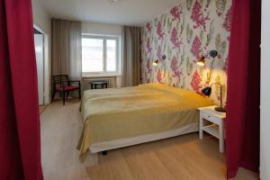 a bedroom with a yellow bed and a window at Forenom Serviced Apartments Helsinki Kruununhaka in Helsinki