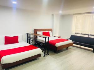 2 camas en una habitación con sábanas rojas y blancas en APARTAESTUDIO AMOBLADO DE UN SOLO AMBIENTE- QUINTA PAREDES CORFERIAS, en Bogotá