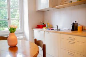 une cuisine avec une table et un vase avec des fleurs. dans l'établissement Casa Reseghina - WelcHome, à Cannobio