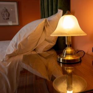 una lampada su un tavolo accanto a un letto di The Fanny Talbot a Barmouth