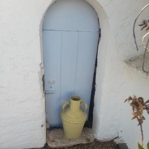 un vaso giallo seduto accanto a una porta di Monte da Lagoa ad Altura