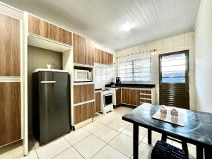 Una cocina con un refrigerador negro y una mesa. en Casa Jardim Cataratas na região dos Atrativos, en Foz do Iguaçu 36 fotos más