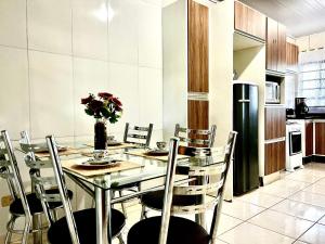 Un comedor con una mesa y sillas en una cocina. en Casa Jardim Cataratas na região dos Atrativos, en Foz do Iguaçu