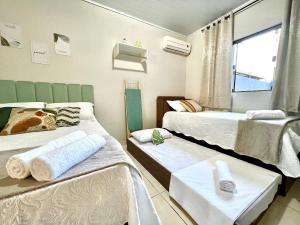 Una pequeña habitación con dos camas y una ventana. en Casa Jardim Cataratas na região dos Atrativos, en Foz do Iguaçu