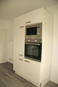 a kitchen with white cabinets and a microwave at Ferienwohnung Bellmann in Prinzenmoor