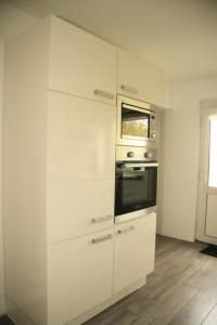 a kitchen with white cabinets and an oven at Ferienwohnung Bellmann in Prinzenmoor