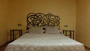 a bed with a white bedspread and a wooden headboard at Albergue La Casa Del Peregrino in El Acebo de San Miguel