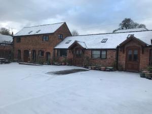 une maison en briques avec de la neige sur le toit dans l'établissement Nuneaton - Cottage - Sleeps 2 - Parking - Garden, à Nuneaton