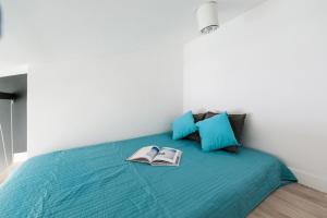 Un dormitorio con una cama azul con dos libros. en SuperApart Rakowiecka 43a, en Varsovia