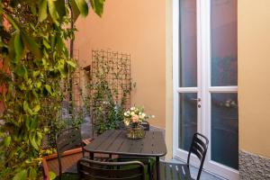una mesa y sillas con flores en el patio en Home Waves Como, en Como